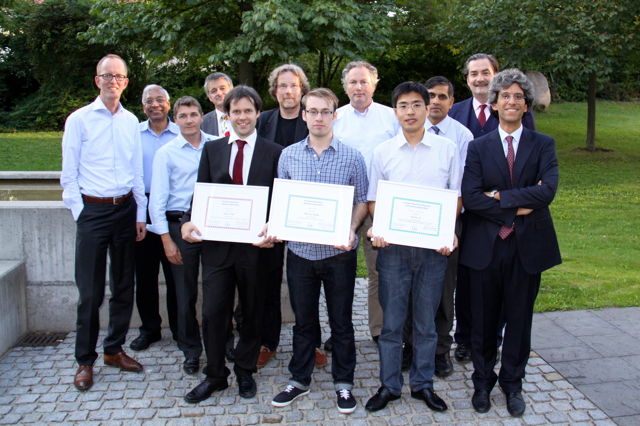 [Photo] Winners of the Awards 2013 together with the jury: Front (left to right): Tom Kevenaar, Jean-Christophe Fondeur, Peter Wild, Finnian Kelly, Huiibin Li, Patrizio Campisi – Back (left to right): Anil Jain, Christoph Busch, Raymond Veldhuis, Günther Schumacher, Ajay Kumar, Alexander Nouak